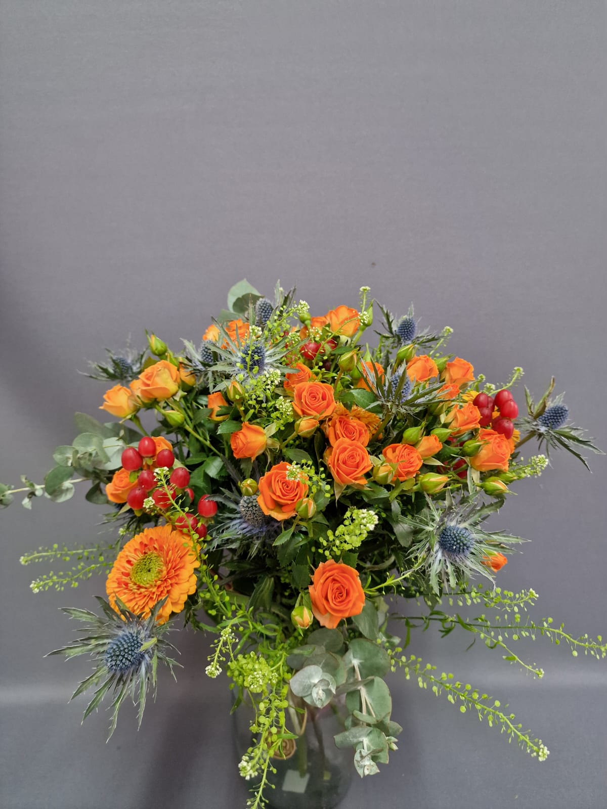 Μπουτον τριαντάφυλλα Εντυπωσιακή ανθοδέσμη που συνδυάζει τριαντάφυλλα spray, ζέρμπερες μίνι, ερύγγιο, θλάσπι και ευκάλυπτο.